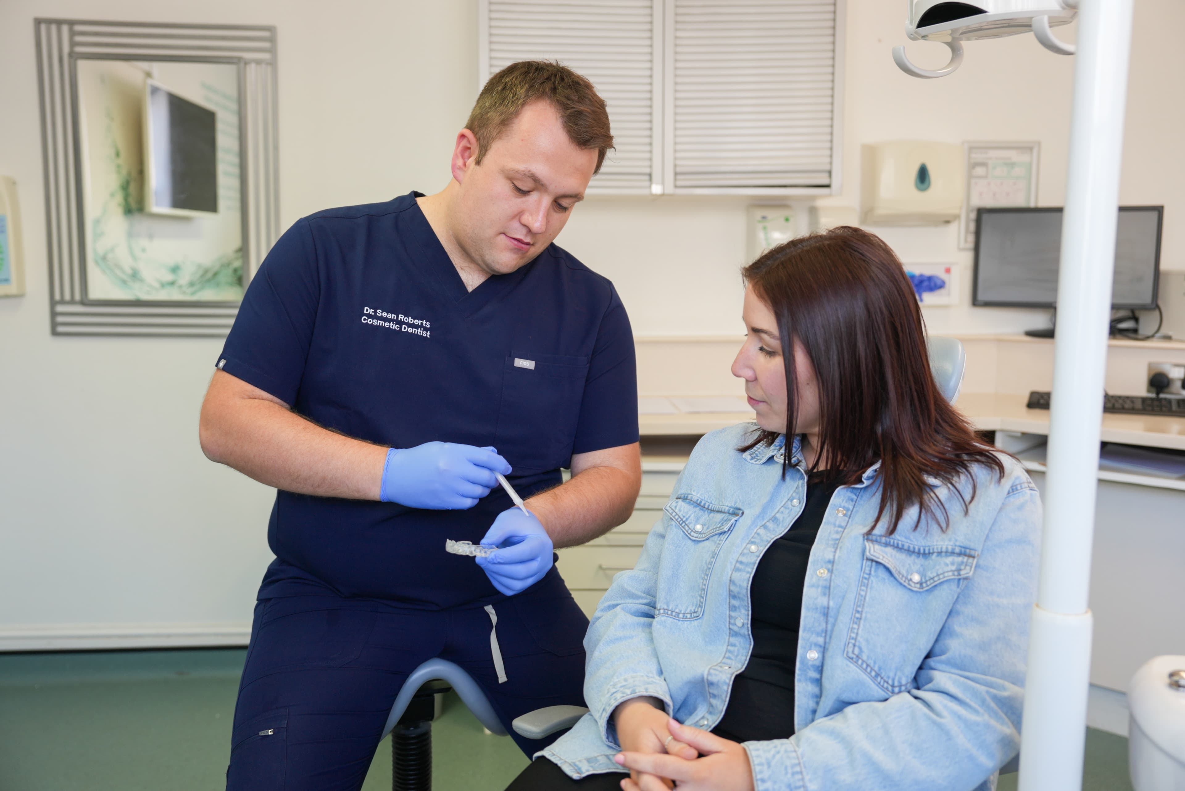 Dr Sean Roberts explaining a clear dental aligner to a patient