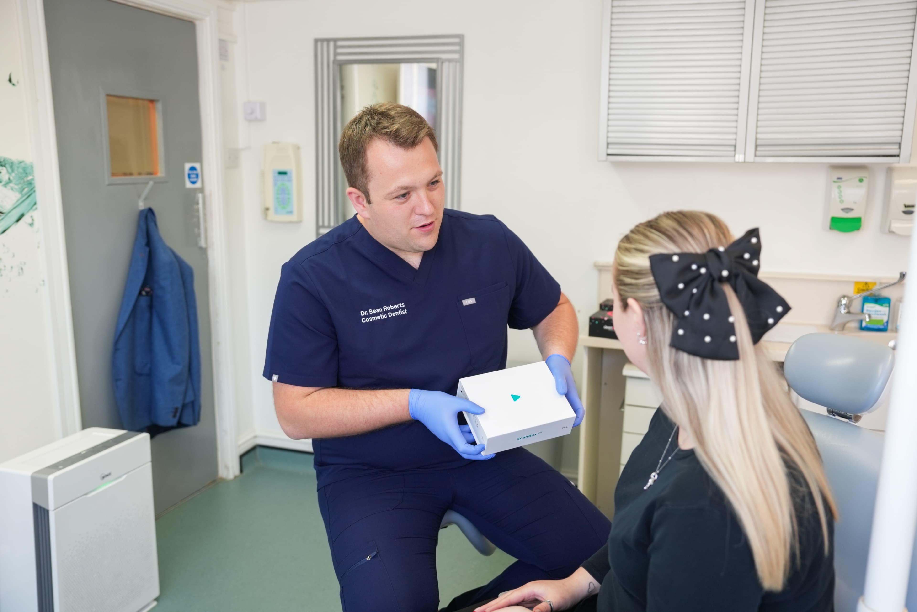Dr Sean Roberts explaining a dental treatment kit to a patient