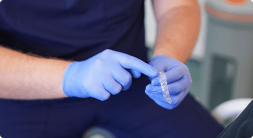Dr Sean Roberts demonstrating a clear dental aligner during Invisalign treatment