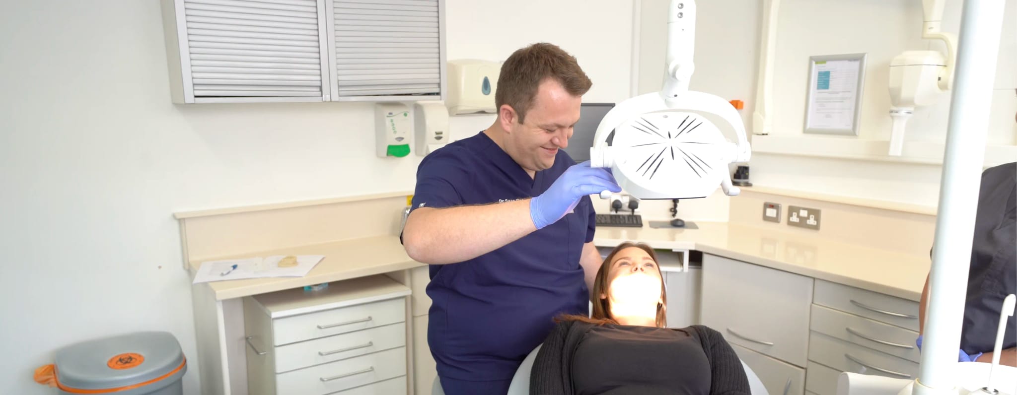 Dr Sean Roberts examining a patient in a dental chair