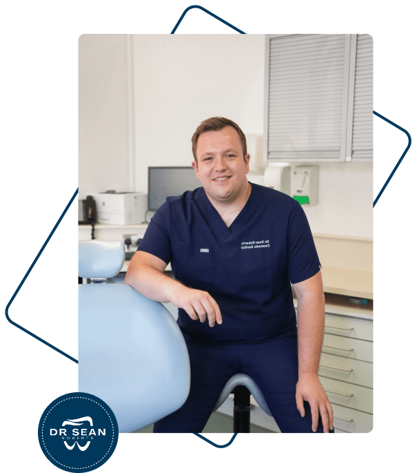 Dr Sean Roberts seated beside a dental chair