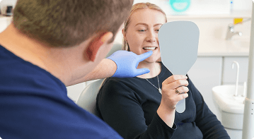 Dr Sean Roberts examining a patient's tooth during a dental assessment in Aberystwyth